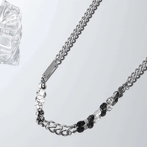 Detail of a Cuban chain necklace with marble beads and an engraved Forever metal plate