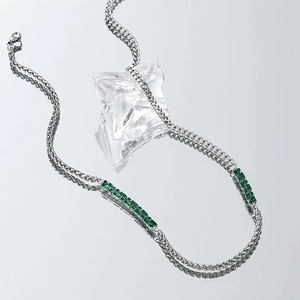 Silver woven chain necklace featuring emerald-cut green zircons in a vintage design