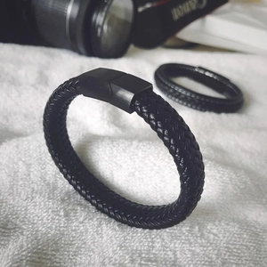Détail d'un bracelet en cuir noir tressé avec fermoir magnétique en métal poli