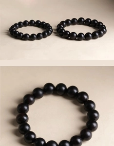 Close-up detail of vintage black sandalwood beads bracelet with subtle satin finish for men