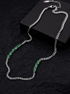 Macro detail of emerald zircon necklace with silver chain on textured black background