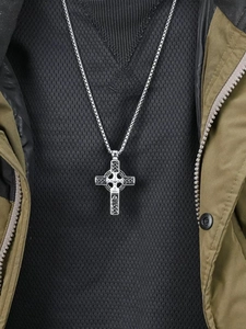Détail macro du collier croix celtique vintage avec motifs de nœuds sur pendentif argenté