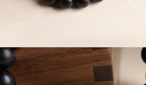 Detailed macro view of matte black round beads with elegant natural wood background