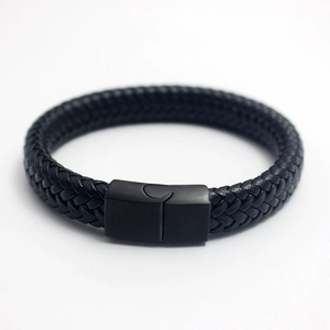 Détail de bracelet en cuir tressé noir avec un fermoir magnétique en métal noir mat