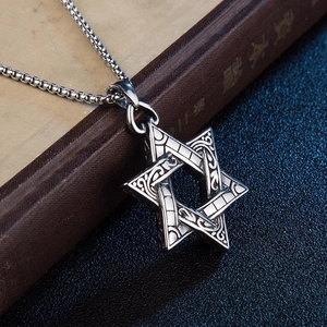 Collier pendentif hexagramme argenté vintage avec gravures sur un vieux livre
