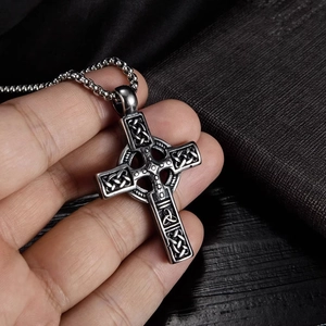 Vue détaillée du pendentif croix celtique avec motifs de nœuds sur chaîne à boules