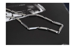 Close-up of a men's silver titanium steel necklace with geometric rhombic cut links