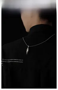 Gros plan d'un pendentif hexagramme géométrique sur une chaîne à billes argentée pour hommes