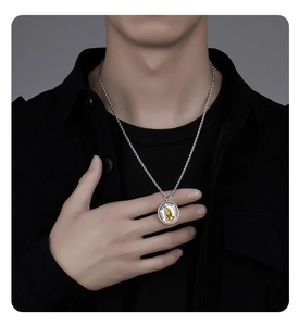 Detail of rope chain necklace featuring a two-tone prayer hands medallion with Latin text