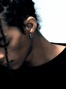 Close-up of a silver thorn twisted rope hoop earring on ear with a vintage minimalist design