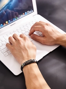 Détail d'un bracelet tibétain avec perle Dzi à neuf yeux et cordon en cuir tressé