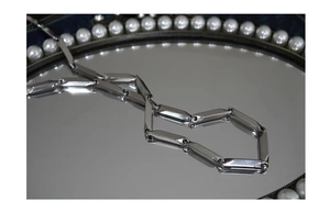 Detailed close-up of a silver rhomboid link chain made of polished stainless steel
