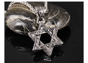 Vue détaillée du pendentif hexagramme avec gravures celtiques sur des pierres sombres