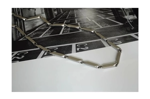Detailed macro view of polished silver titanium steel geometric tube link chain necklace
