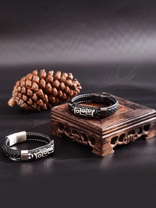 Gros plan de perles tibétaines sur des bracelets en cuir tressé noir avec pives