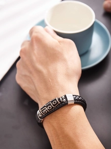 Détail du bracelet en cuir noir tressé avec perle Dzi tibétaine et fermoir en argent