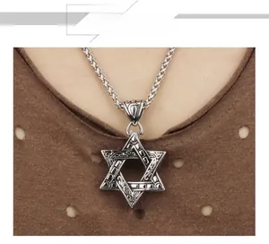 Gros plan d'un pendentif hexagramme vintage avec gravures sur une chaîne à maillons