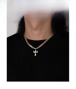 Close-up of double-layered snake chain necklace with cross and angel wing pendant on model