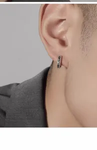 Close-up of vintage silver hoop earring with engraved auspicious cloud pattern on ear