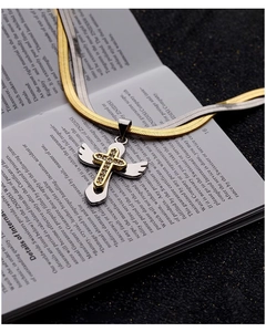 Detailed view of two-tone cross wing pendant with crystal inlay on flat snake chains