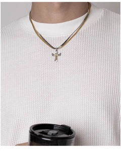 Detailed view of layered snake chain and silver wing cross pendant necklace on a model