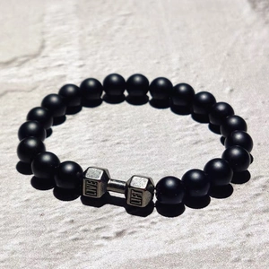 Makroansicht des matt schwarzen Perlenarmbands mit Hantel-Gravur LIVE und LIFT