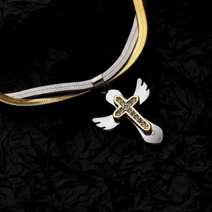 Two-tone snake chain necklace with gold cross and silver bird pendant on black background