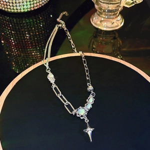 Macro shot of silver asymmetric chain necklace with opal gemstone and star pendant detail