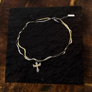 Two-tone silver and gold snake chain necklace with a crystal-encrusted cross pendant