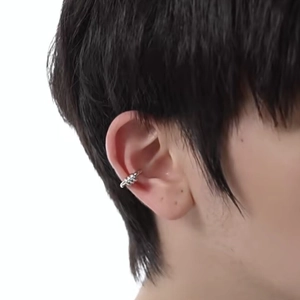 Close-up of a silver cross double-ring ear cuff worn on a model's ear cartilage