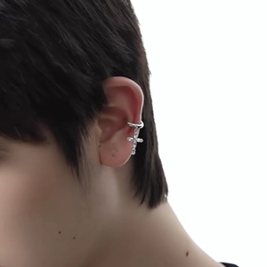 Silver ear cuff featuring a hanging cross charm set with sparkling cubic zirconia