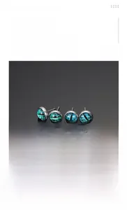 Macro detail of devil eye stud earrings made of silver titanium steel and green glass
