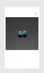 Macro shot of evil eye stud earrings with green glass pupil and polished steel base
