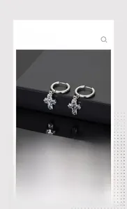 Detailed view of silver cross earrings with sparkling zircon inlay for men and women