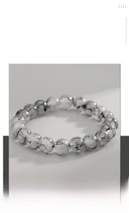 Dettaglio macro delle perle opache grigio inchiostro con texture marmorea sul bracciale