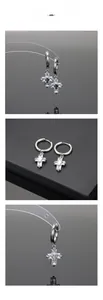 Macro detail of silver titanium cross earrings with shimmering zircon inlays