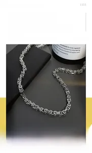 Detailed view of silver Byzantine chain necklace on a black leather display stand