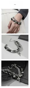 Detail of silver-colored star charm and textured beads on industrial style Cuban bracelet