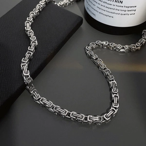 Silver Byzantine chain necklace in stainless steel with square links on dark surface