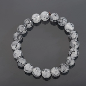 Bracciale in perline di pietra naturale grigio inchiostro con motivi a muschio su piano