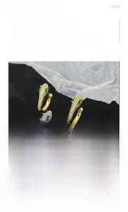 Détail de boucles d'oreilles serpent avec zircons incrustés en finitions or et argent