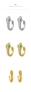 Vue détaillée de boucles d'oreilles serpent serties de zircons et yeux verts brillants