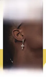 Nahaufnahme von Hip-Hop-Kreuz-Ohrstecker mit Zirkonia-Besatz und poliertem Edelstahl