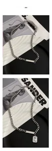 Close-up of silver titanium steel necklace with rectangular zircon pendant and chain detail