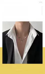 Detail of titanium steel necklace with black star pendant and white pearls on a blazer