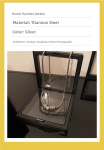 Detail of silver titanium steel rings pendant displayed in a black PE film jewelry box