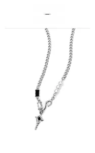 Macro detail of star pendant with black gemstones and industrial chain linkage