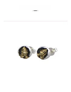 Close-up of vintage round stud earrings featuring a golden praying hands relief design