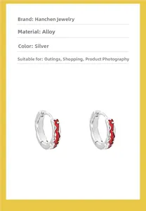 Detail of silver alloy hoop earring featuring vibrant red wave enamel texture and modern design
