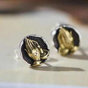 Vintage stainless steel round stud earrings featuring gold praying hands relief